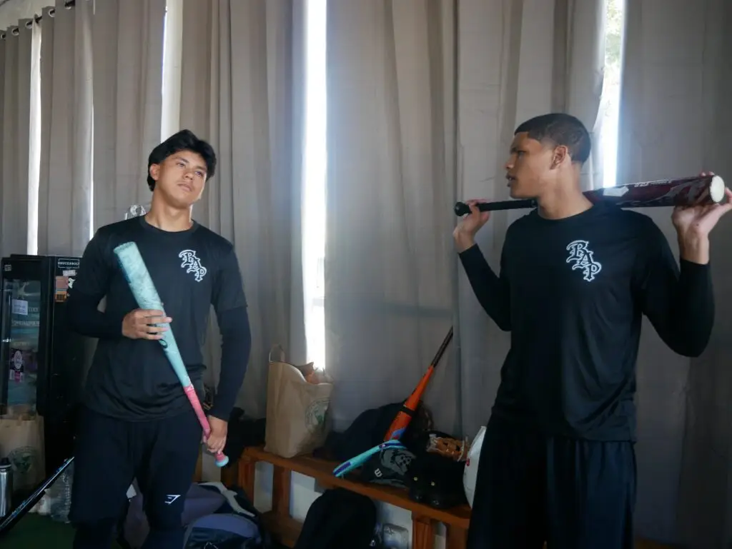 Two BAP players with bats in the clubhouse